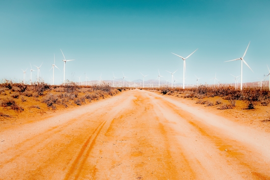 Wind turbine and sandy road desert with blue sky in California USA by Timmy333